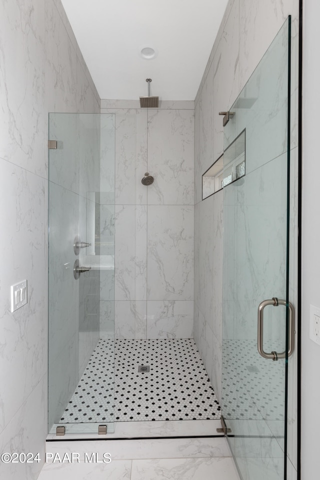 bathroom with a shower with door