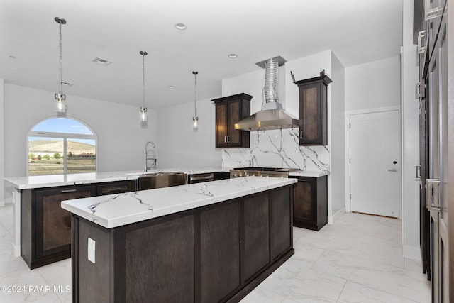 kitchen with a center island, backsplash, wall chimney range hood, hanging light fixtures, and kitchen peninsula