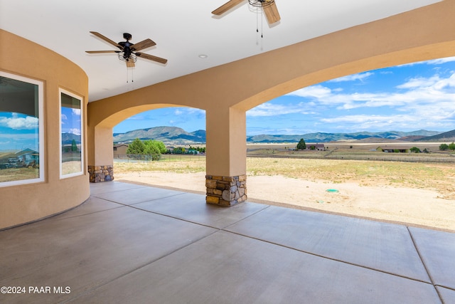 view of patio / terrace featuring a mountain view, ceiling fan, and a rural view