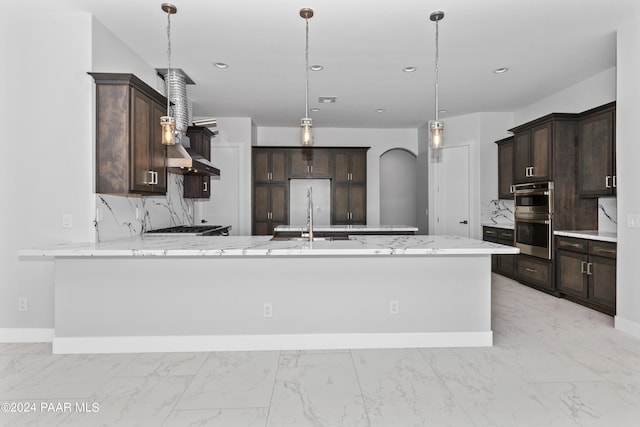 kitchen with pendant lighting, dark brown cabinets, and kitchen peninsula