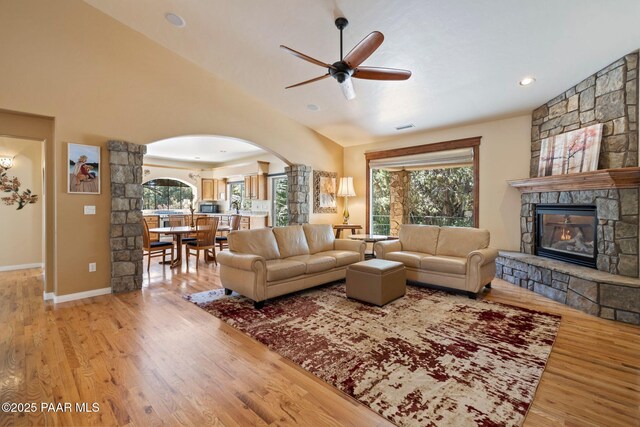 115 E Rosser St, Prescott, AZ 86301 - living area with arched walkways, a stone fireplace, ceiling fan, light wood-type flooring, and lofted ceiling