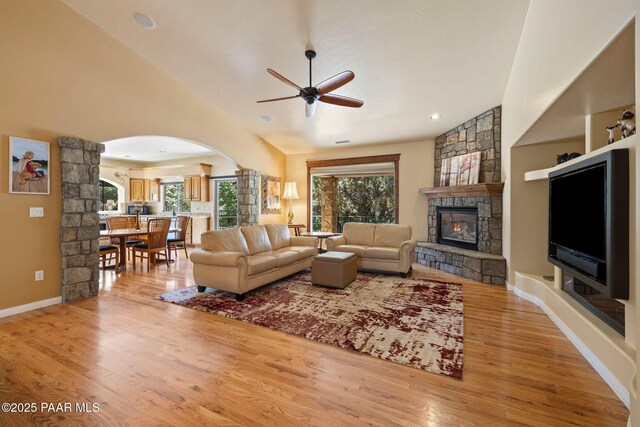 115 E Rosser St, Prescott, AZ 86301 - living area with a ceiling fan, a stone fireplace, arched walkways, and light wood-type flooring