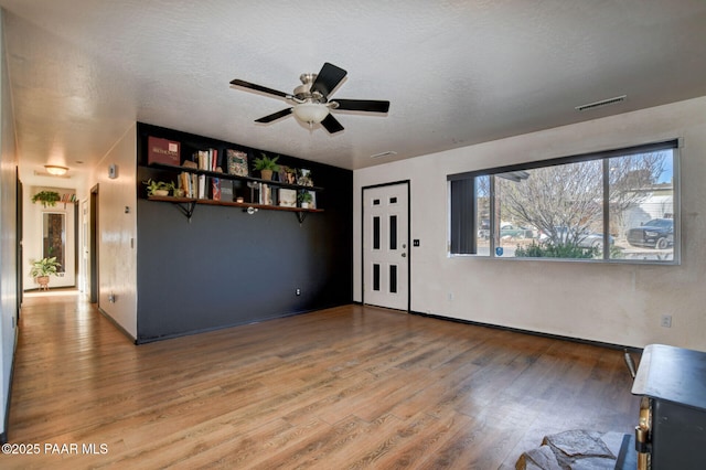 unfurnished living room featuring hardwood / wood-style floors, a textured ceiling, and ceiling fan