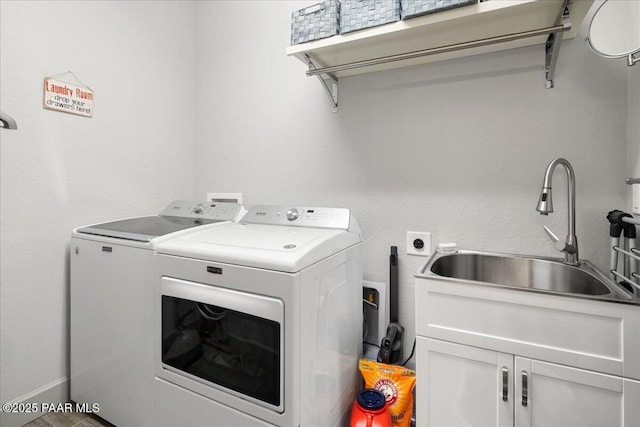 laundry area with a sink, cabinet space, and separate washer and dryer