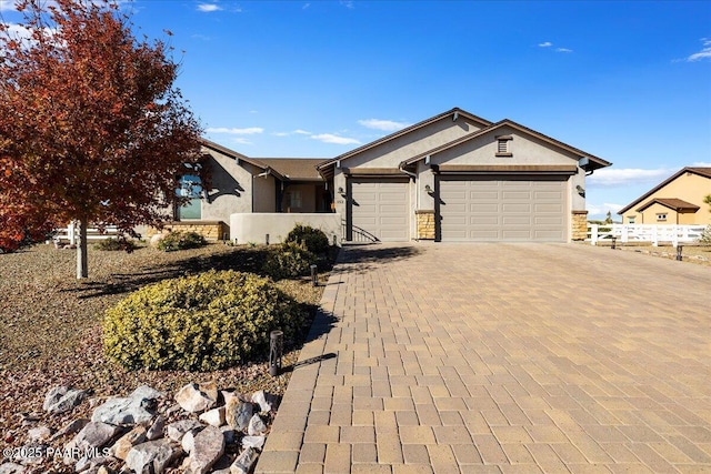 ranch-style home featuring decorative driveway, an attached garage, and stucco siding
