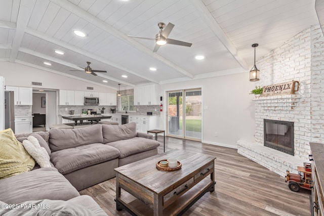 502 E Le Marche Ave, Phoenix, AZ 85022 - living room featuring visible vents, lofted ceiling with beams, wood finished floors, a fireplace, and baseboards
