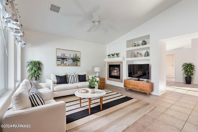 living room featuring built in features, ceiling fan, lofted ceiling, and light tile patterned flooring