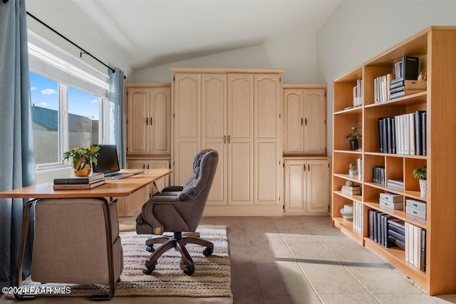 tiled office space featuring vaulted ceiling