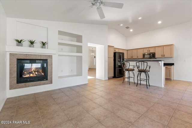 kitchen with a breakfast bar, ceiling fan, refrigerator with ice dispenser, light brown cabinets, and built in features