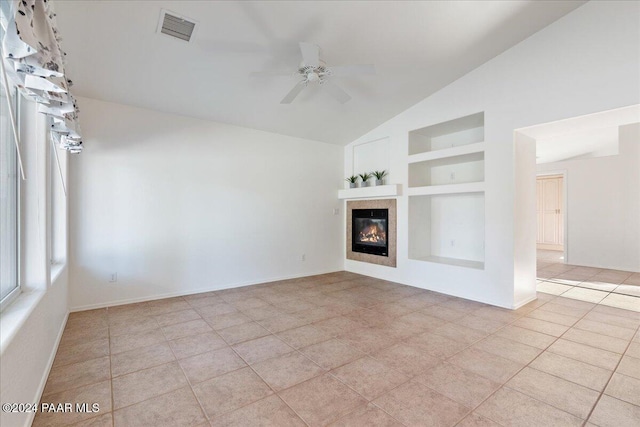 unfurnished living room featuring ceiling fan, built in features, light tile patterned floors, and vaulted ceiling