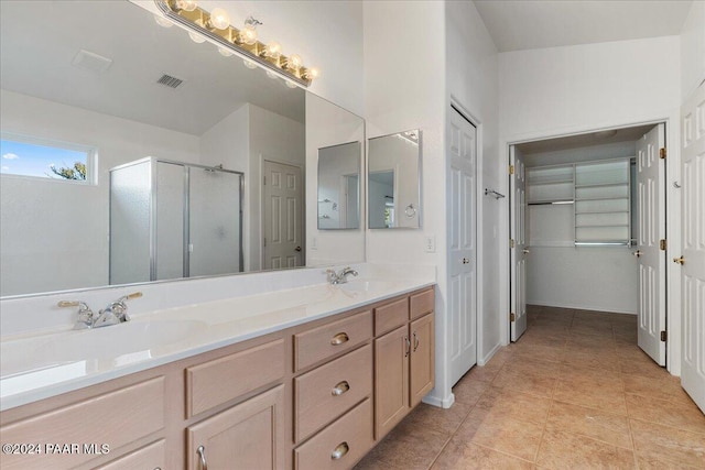 bathroom with tile patterned flooring, vanity, and a shower with shower door