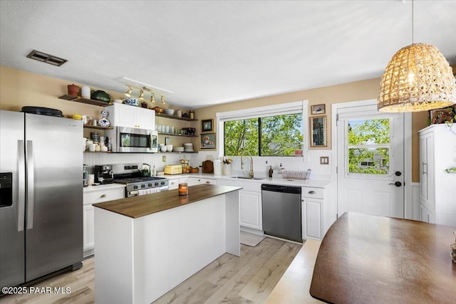 714 Mingus Ave, Prescott, AZ 86301 - kitchen with stainless steel appliances, open shelves, white cabinets, and light wood-type flooring