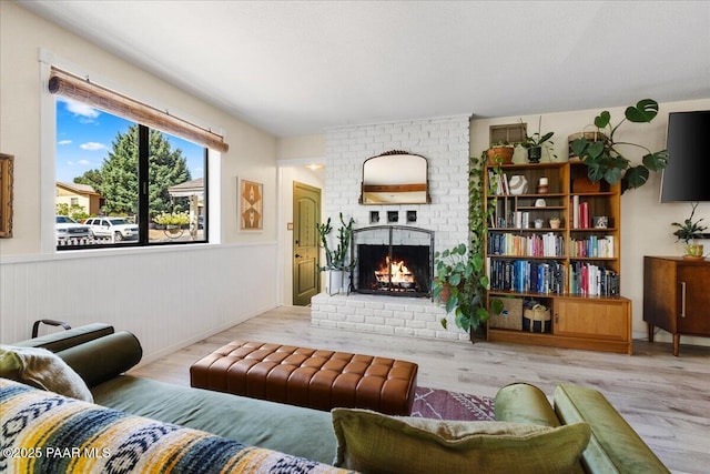 714 Mingus Ave, Prescott, AZ 86301 - living area featuring a brick fireplace, wood finished floors, and a wainscoted wall