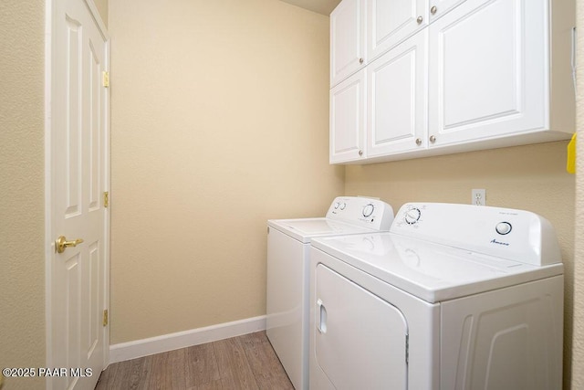 laundry room with light hardwood / wood-style floors, cabinets, and independent washer and dryer