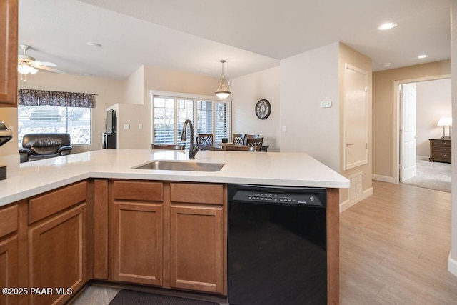 kitchen with dishwasher, sink, a wealth of natural light, and light hardwood / wood-style flooring