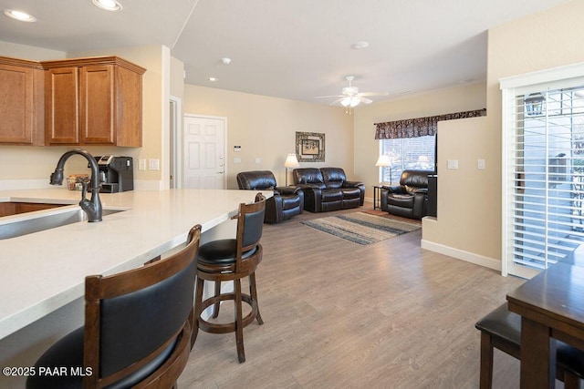 kitchen with light wood-type flooring, ceiling fan, and sink