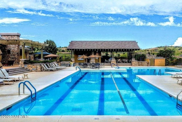 view of pool with a pergola and a patio