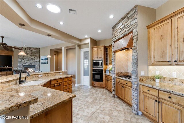 1183 Northridge Dr, Prescott, AZ 86301 - kitchen with stainless steel appliances, a stone fireplace, tasteful backsplash, light stone countertops, and recessed lighting