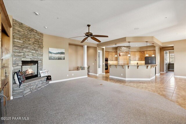 1183 Northridge Dr, Prescott, AZ 86301 - unfurnished living room featuring ceiling fan, a fireplace, light tile patterned floors, and light carpet