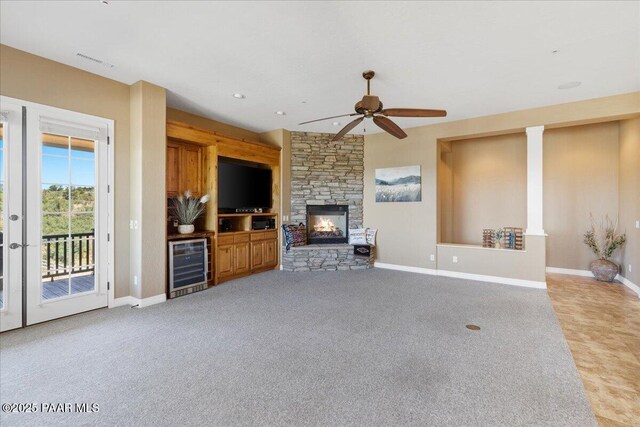 1183 Northridge Dr, Prescott, AZ 86301 - unfurnished living room featuring wine cooler, ceiling fan, carpet flooring, a stone fireplace, and recessed lighting