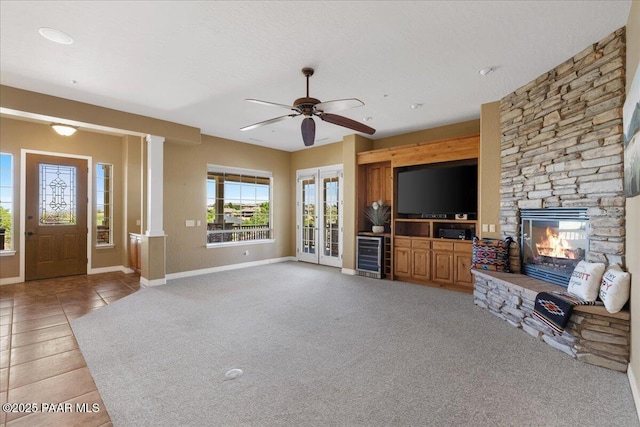 1183 Northridge Dr, Prescott, AZ 86301 - unfurnished living room with wine cooler, a fireplace, a ceiling fan, french doors, and light tile patterned floors