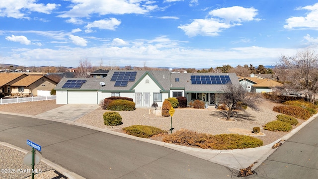 view of front facade with a garage and solar panels