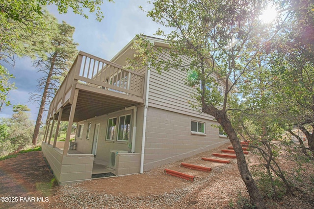 1251 Navajo Way, Prescott, AZ 86305 - view of property exterior featuring a wooden deck, concrete block siding, and a cooling unit