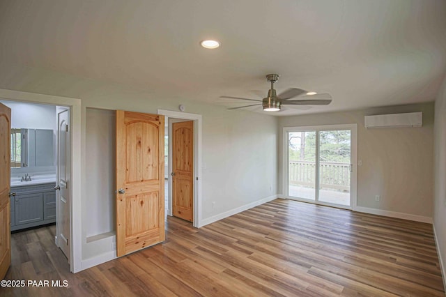1251 Navajo Way, Prescott, AZ 86305 - unfurnished room featuring an AC wall unit, baseboards, ceiling fan, a sink, and wood finished floors