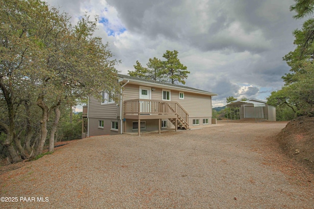 1251 Navajo Way, Prescott, AZ 86305 - rear view of house featuring an outbuilding, dirt driveway, stairway, and a wooden deck