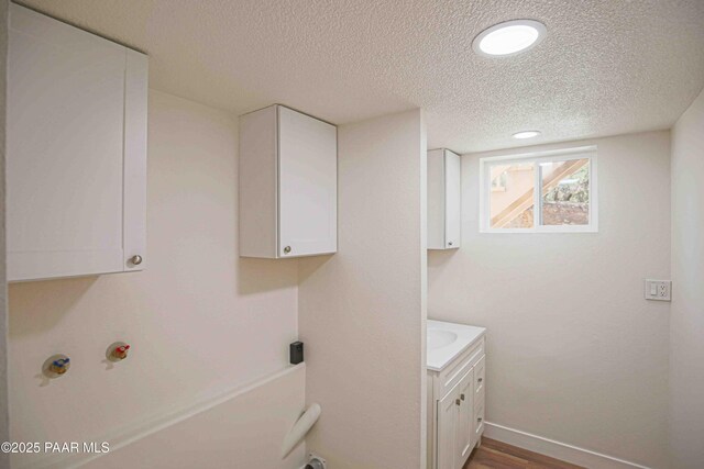 1251 Navajo Way, Prescott, AZ 86305 - laundry area with cabinet space, a textured ceiling, baseboards, dark wood-style floors, and recessed lighting