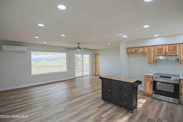 1251 Navajo Way, Prescott, AZ 86305 - kitchen featuring stainless steel electric range, a wall unit AC, under cabinet range hood, light countertops, and light wood-style floors