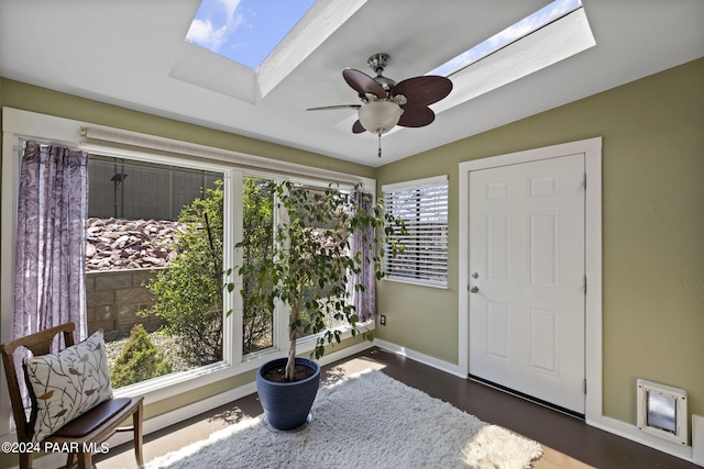 sunroom / solarium featuring ceiling fan and vaulted ceiling with skylight