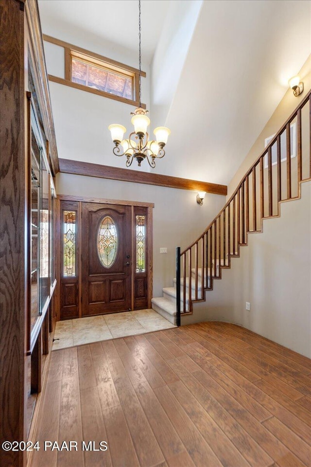 14420 Jagged Tooth Trl, Mayer, AZ 86333 - foyer featuring plenty of natural light, light wood-type flooring, a high ceiling, and a chandelier