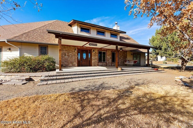 14420 Jagged Tooth Trl, Mayer, AZ 86333 - view of front of home featuring a shingled roof, stone siding, a chimney, and covered porch