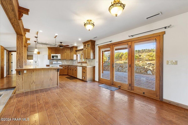 14420 Jagged Tooth Trl, Mayer, AZ 86333 - kitchen with white appliances, dark hardwood / wood-style floors, ceiling fan, decorative backsplash, and decorative light fixtures