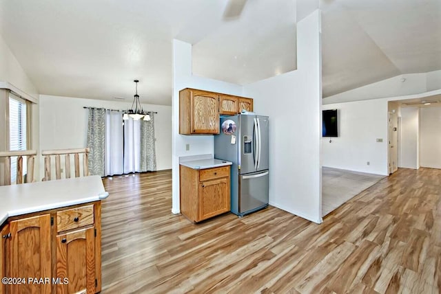 kitchen featuring stainless steel fridge with ice dispenser, light hardwood / wood-style flooring, pendant lighting, and lofted ceiling