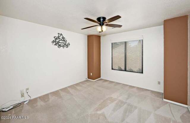 empty room with ceiling fan and light colored carpet