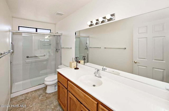 bathroom featuring vanity, toilet, and a shower with shower door