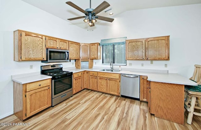 kitchen with high vaulted ceiling, sink, ceiling fan, light wood-type flooring, and appliances with stainless steel finishes