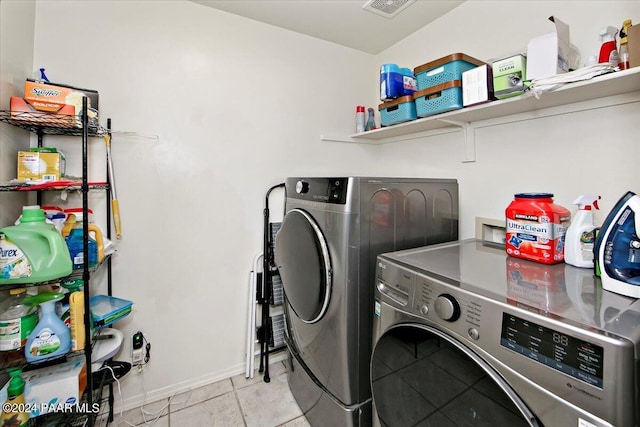 washroom with washing machine and dryer and light tile patterned flooring