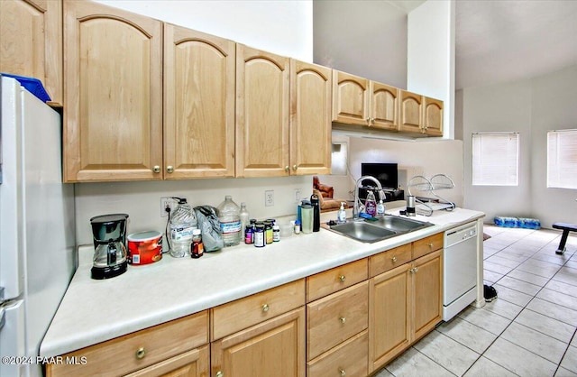 kitchen with sink, white appliances, light brown cabinets, and light tile patterned flooring