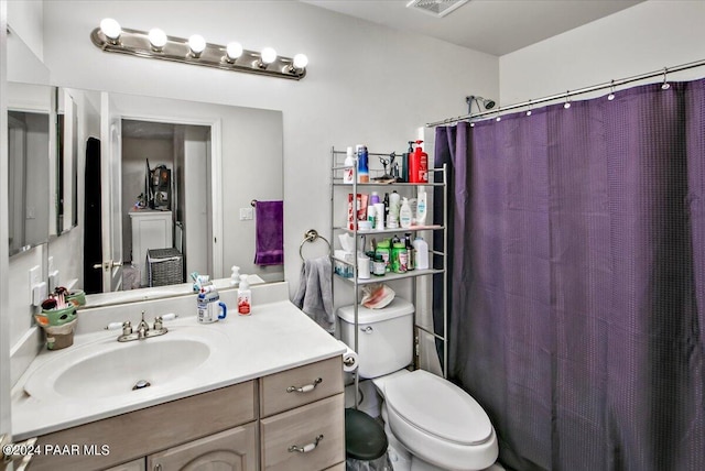 bathroom with vanity, a shower with shower curtain, and toilet