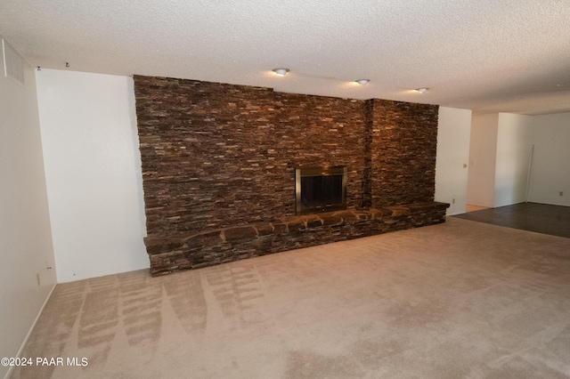 unfurnished living room featuring a large fireplace, carpet, and a textured ceiling