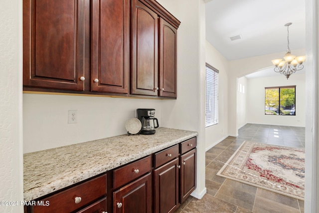 7590 E Traders Trl, Prescott Valley, AZ 86314 - kitchen with light stone countertops, pendant lighting, and a chandelier
