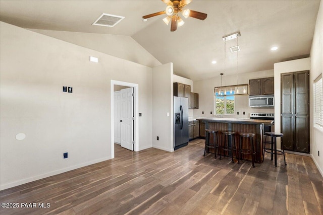 17940 E Native Dancer Ln, Dewey-Humboldt, AZ 86327 - kitchen with stainless steel appliances, a center island, a breakfast bar area, dark wood-type flooring, and ceiling fan
