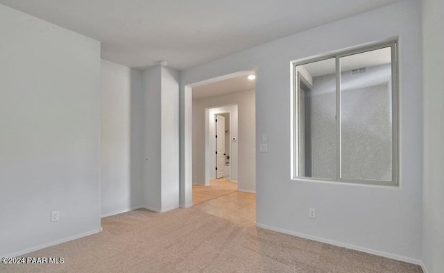 unfurnished room featuring light colored carpet