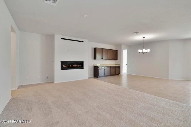 unfurnished living room featuring light carpet and an inviting chandelier