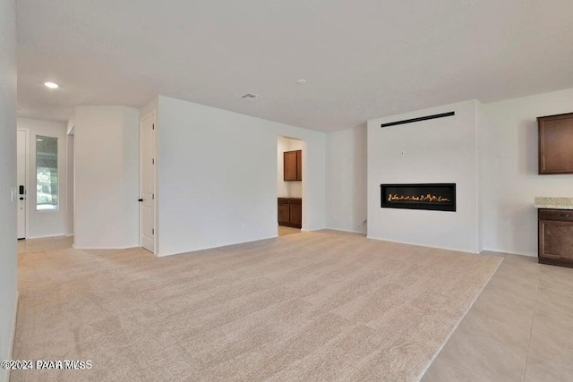 unfurnished living room with light colored carpet