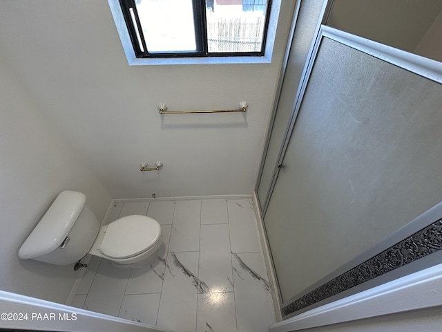 bathroom with an enclosed shower, toilet, baseboards, and marble finish floor