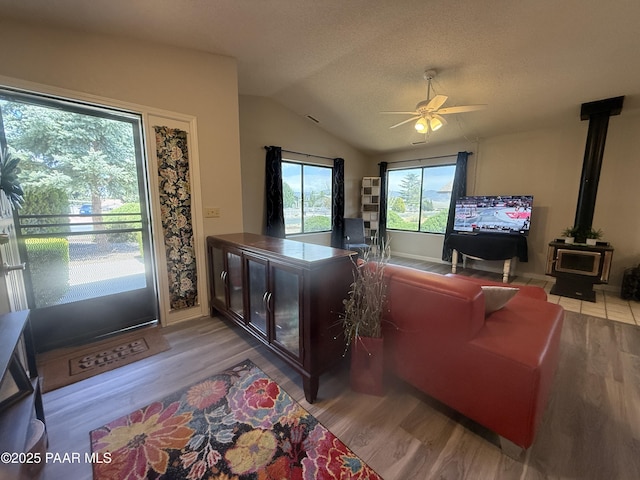 9521 E Glencove Cir Unit 20, Prescott Valley, AZ 86314 - living room with a ceiling fan, lofted ceiling, a wood stove, and light wood-style floors